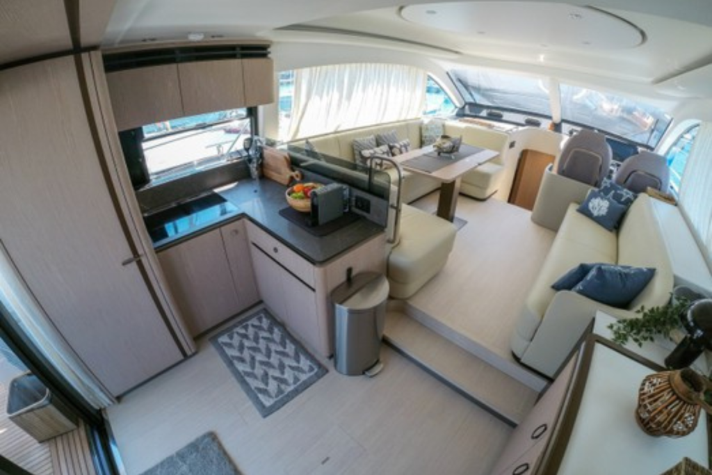 Salón del yate Azimut 53 Sea Shell, con diseño elegante, amplios sofás y ventanales que ofrecen vistas panorámicas al mar