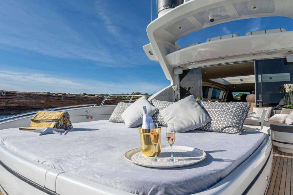 Solárium del yate Mangusta 92, con cómodas tumbonas y vistas panorámicas, diseñado para disfrutar del sol y la brisa marina en total exclusividad.