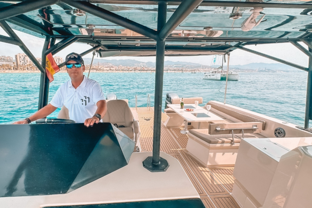 Capitán del Catamarán Alexa al timón, garantizando una navegación segura y placentera en las aguas de Barcelona.