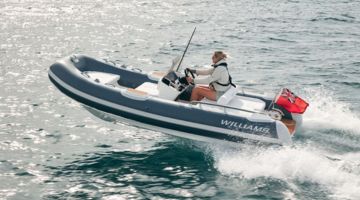Tender boat cruising through crystal-clear waters, perfect for comfortable transfers.